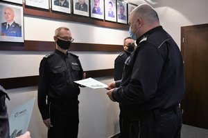 Komendant Wojewódzka Policji w Katowicach wręcza oficerowi rozkaz personalny.