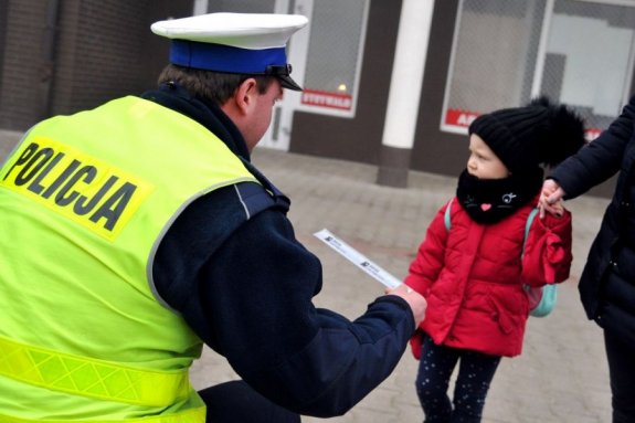 policjant przekazuje odblask małemu dziecku