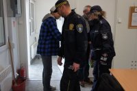 policjantka podaje ręke bezdomnemu. Obok strażnik miejski