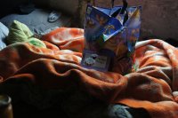 kartka i paczka na łóżku u bezdomnego w pstostanie