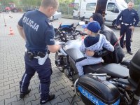 Policjant WRD, motor oraz małe dziecko, które siedzi na motorze.