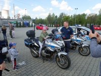 Policyjny motor, policjant i dziecko zainteresowane motorem.