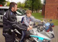 Policjant, który pokazuje chłopcu policyjny motor.