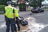 policjanci wykonują czynności na miejscu wypadku, widać zniszczony motocykl oraz uszkodzone bmw