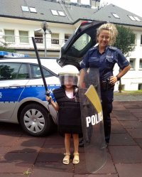 Policjantka wraz z dziewczynkom ubraną w policyjny sprzęt.