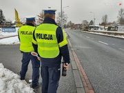 Dwóch policjantów ruchu drogowego stoi przy drodze