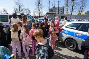 Na zdjęciu widać jak dzieci oglądają policyjny radiowóz.